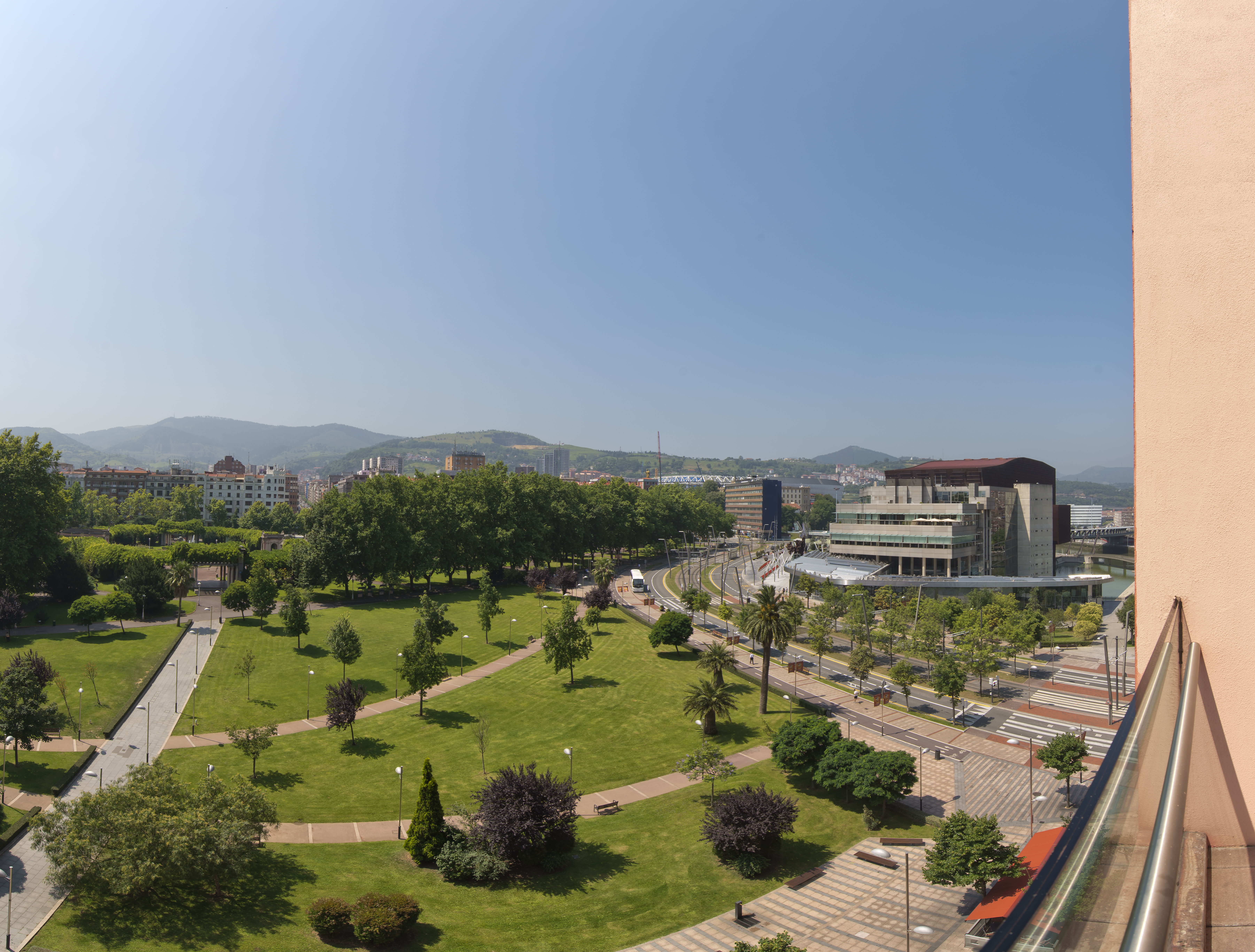 a park with trees and buildings in the background