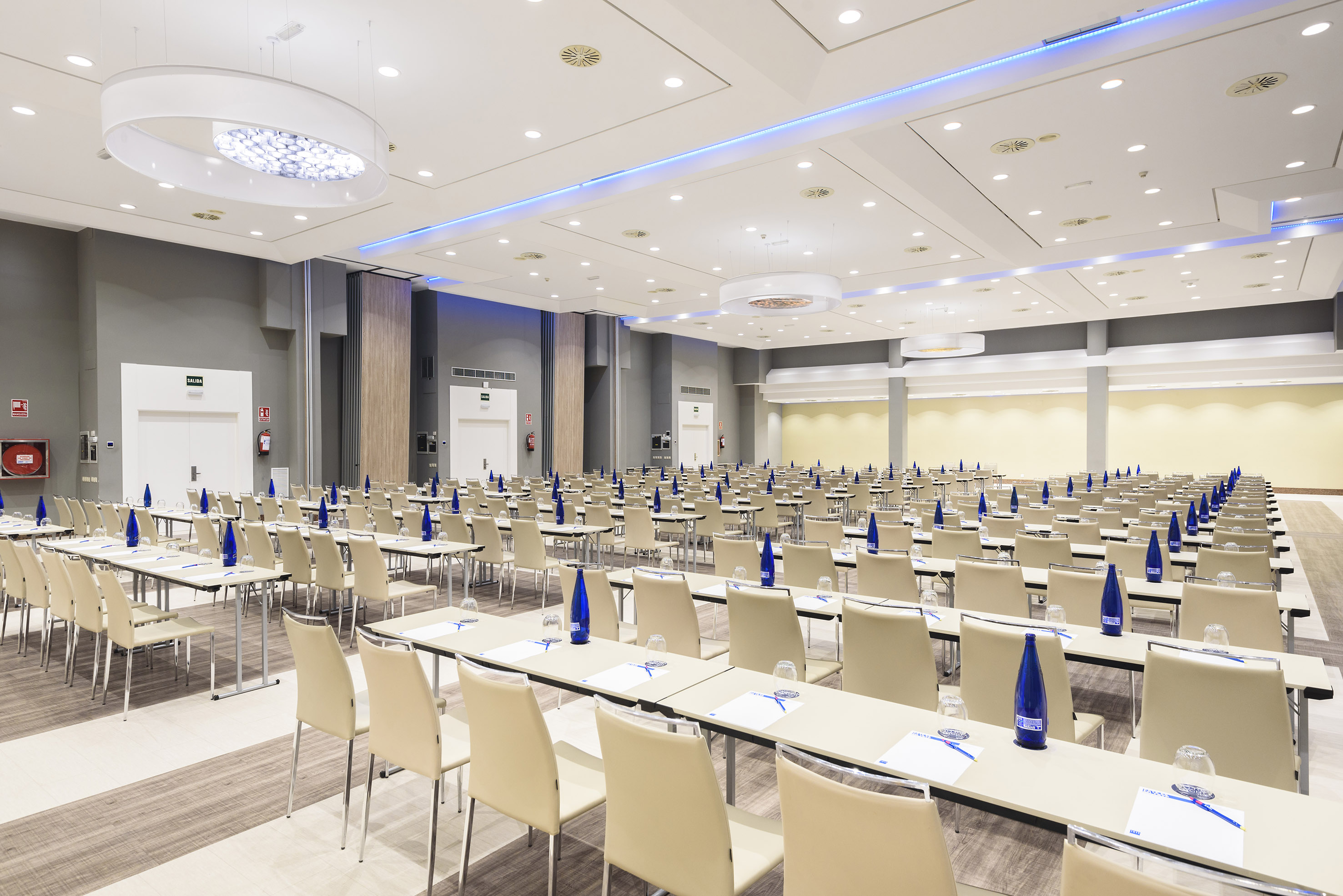 Empty modern conference room setup with rows of tables and chairs.