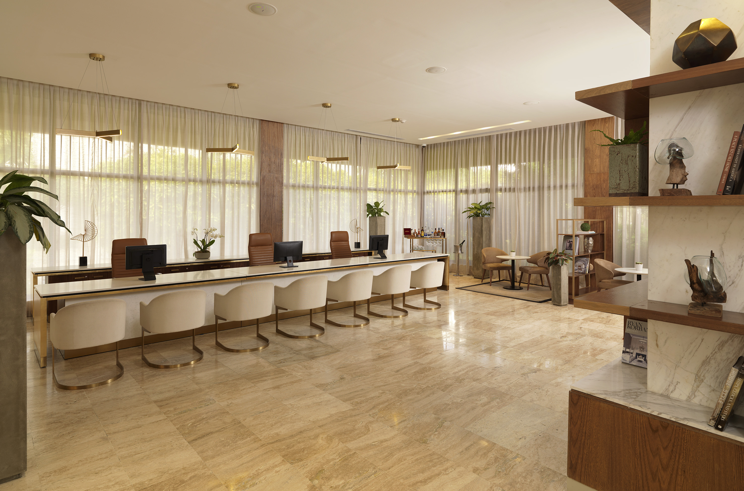 Modern reception lobby with long desk, elegant chairs, marble floor, and lounge.