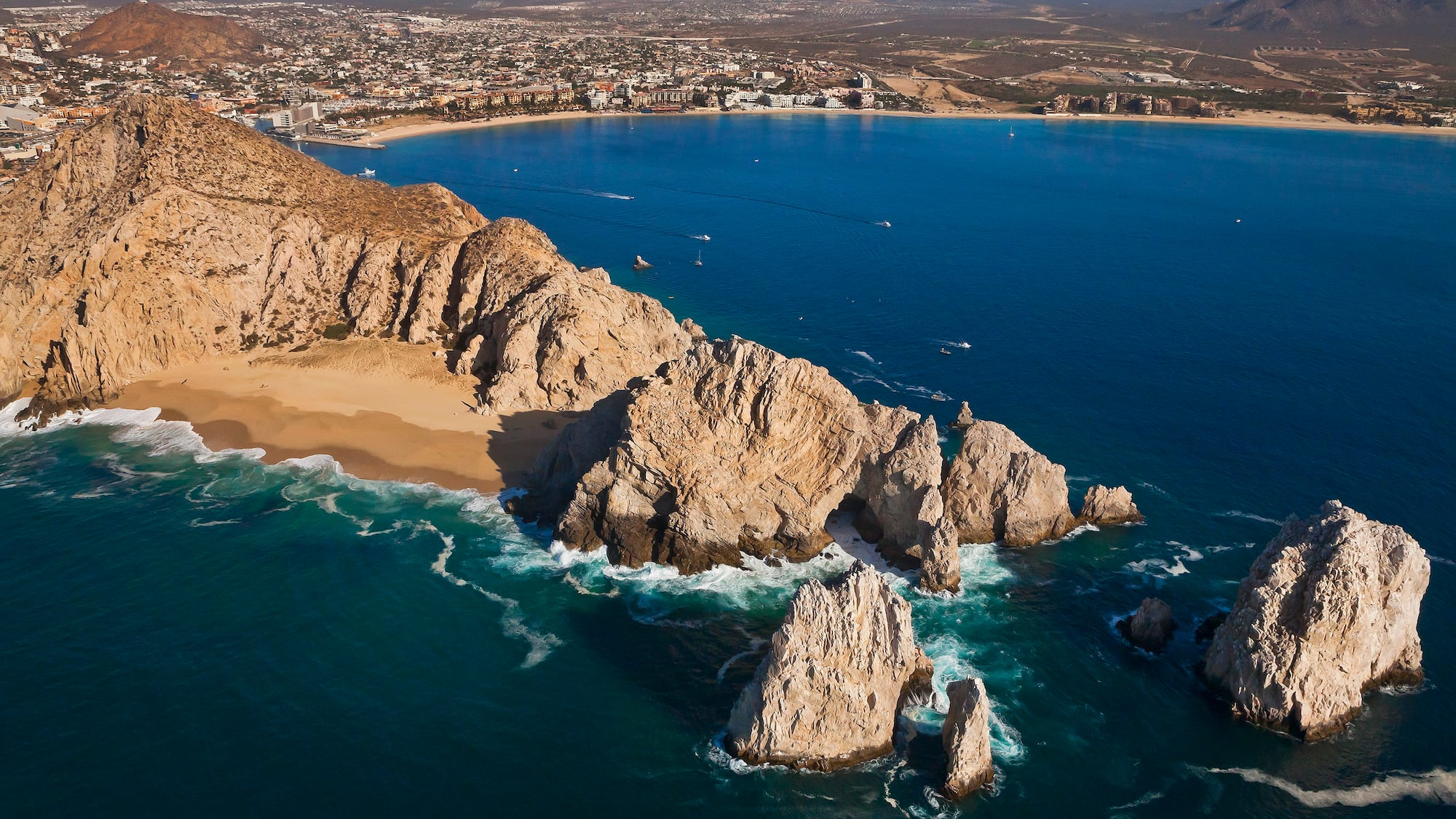 a rocky beach with a city in the background