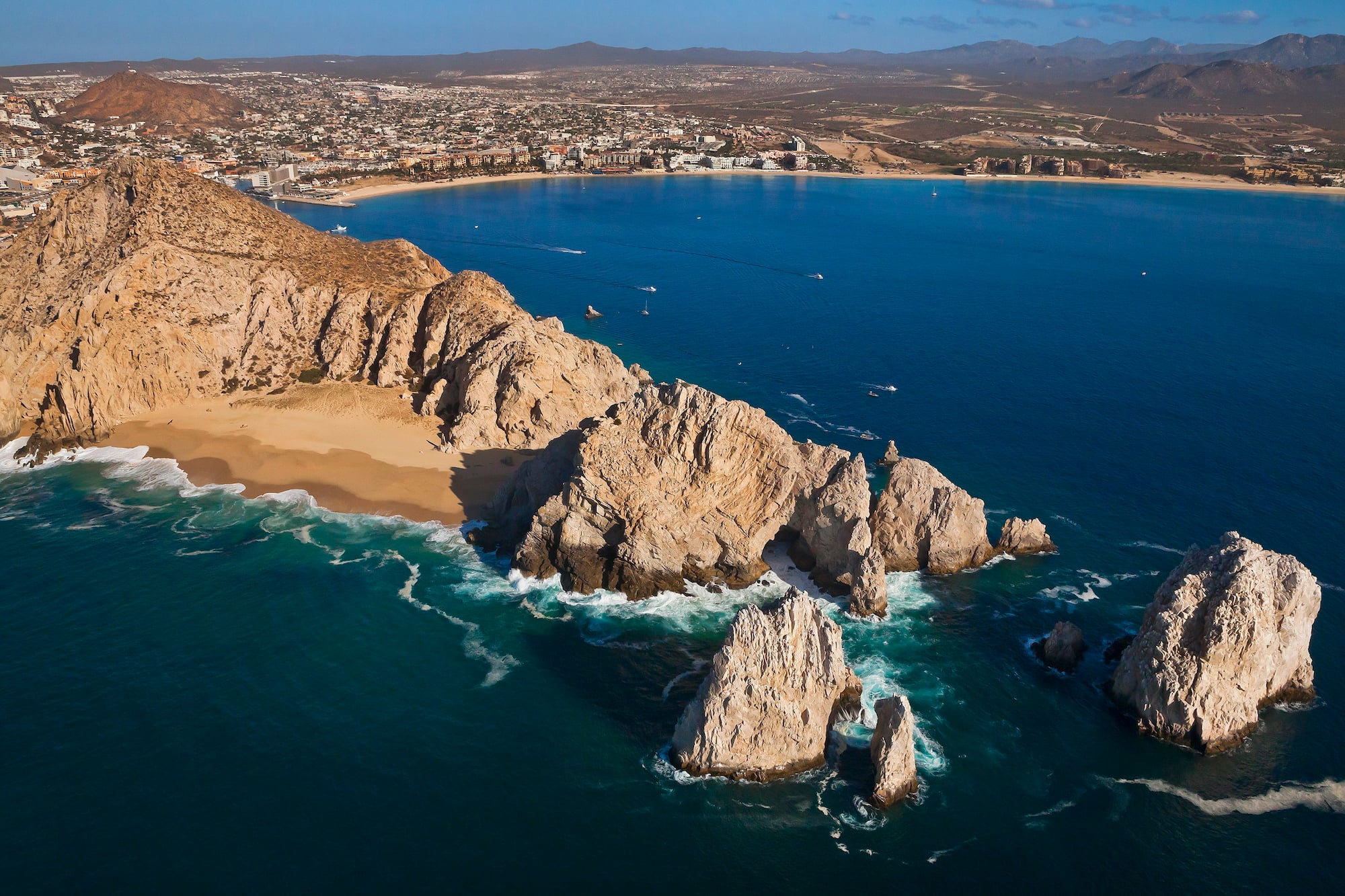 a rocky beach with a city in the background