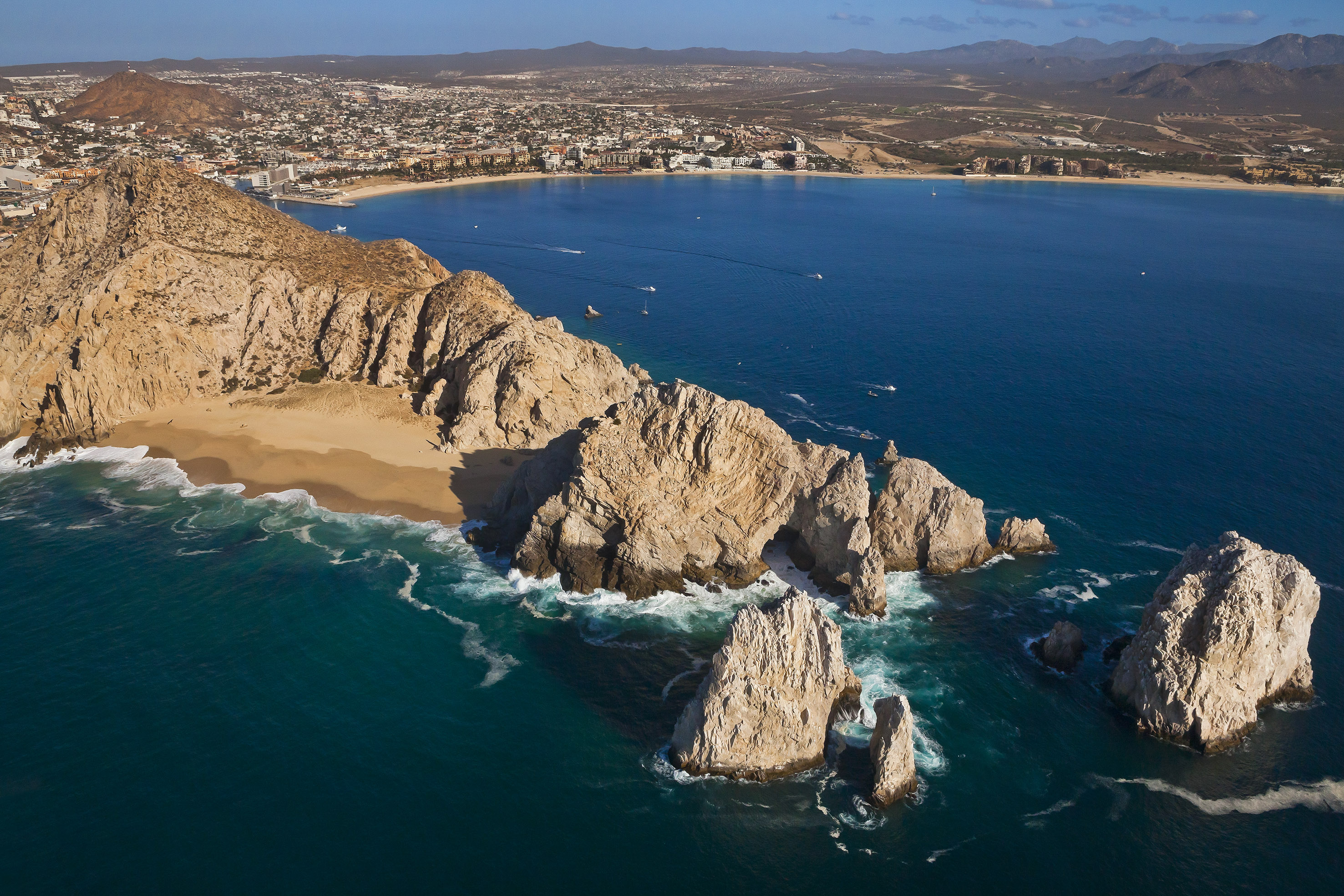 a rocky beach with a city in the background