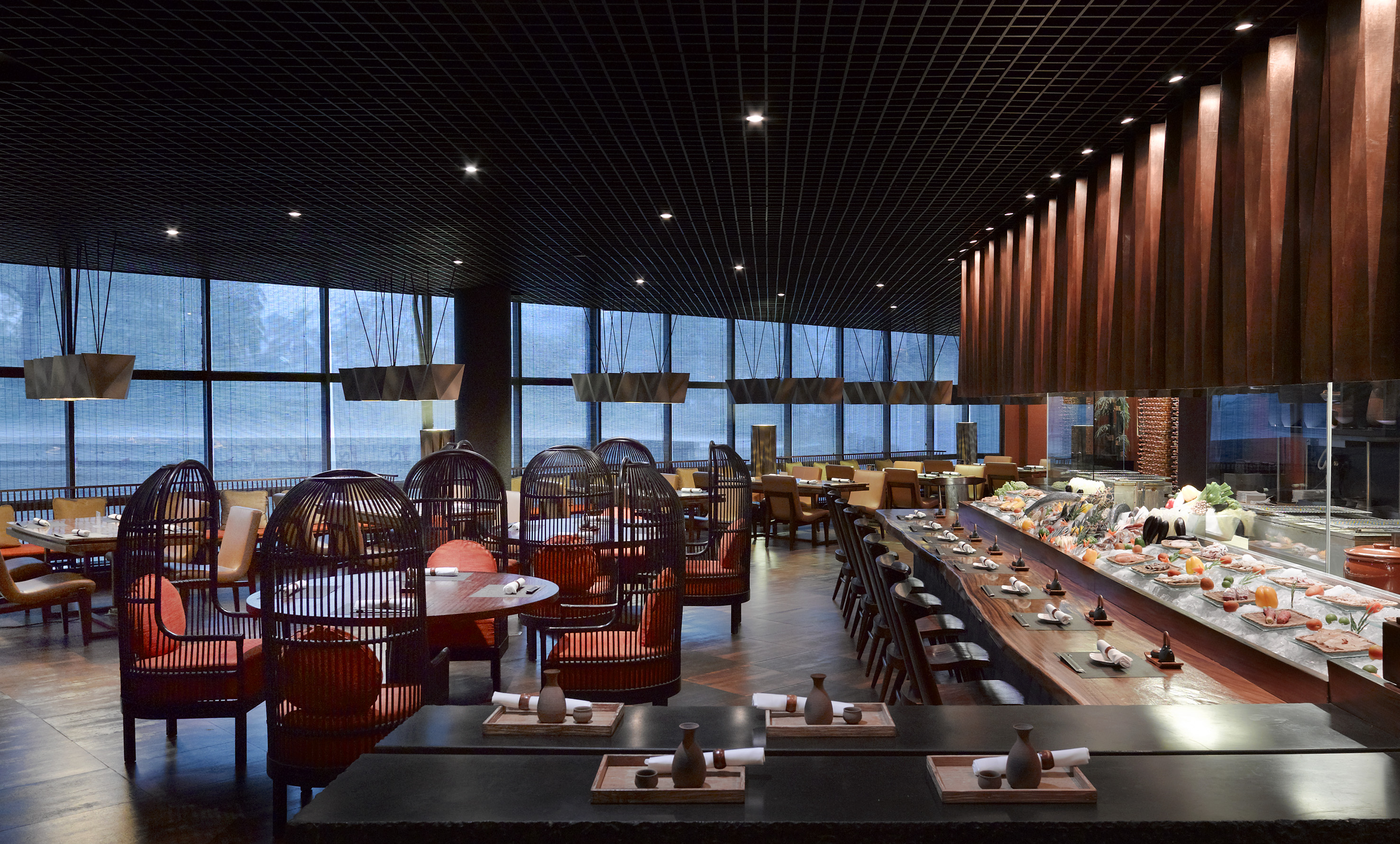 Elegant Japanese restaurant interior with sushi counter and modern cage chairs.