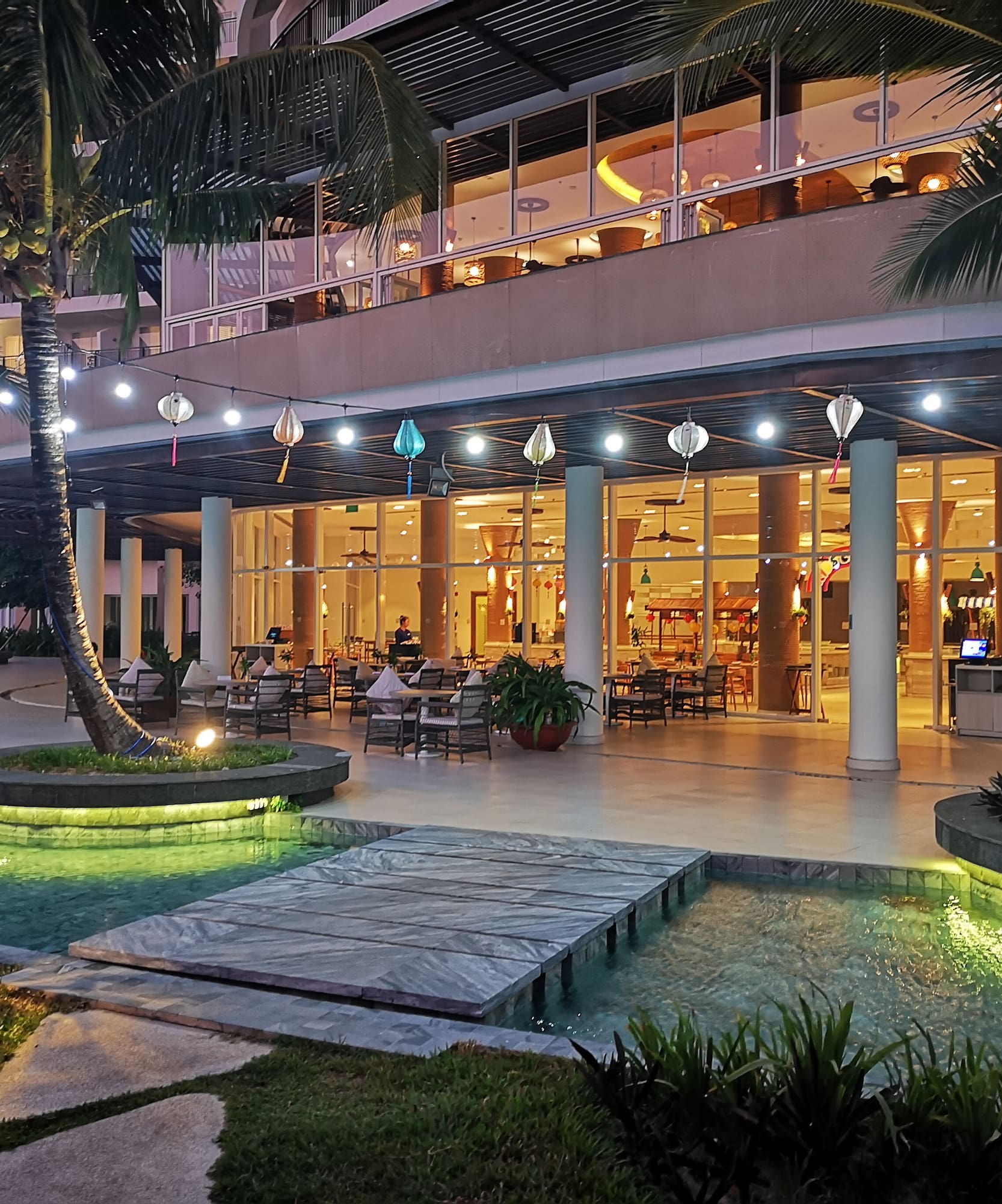 a building with a pool and palm trees