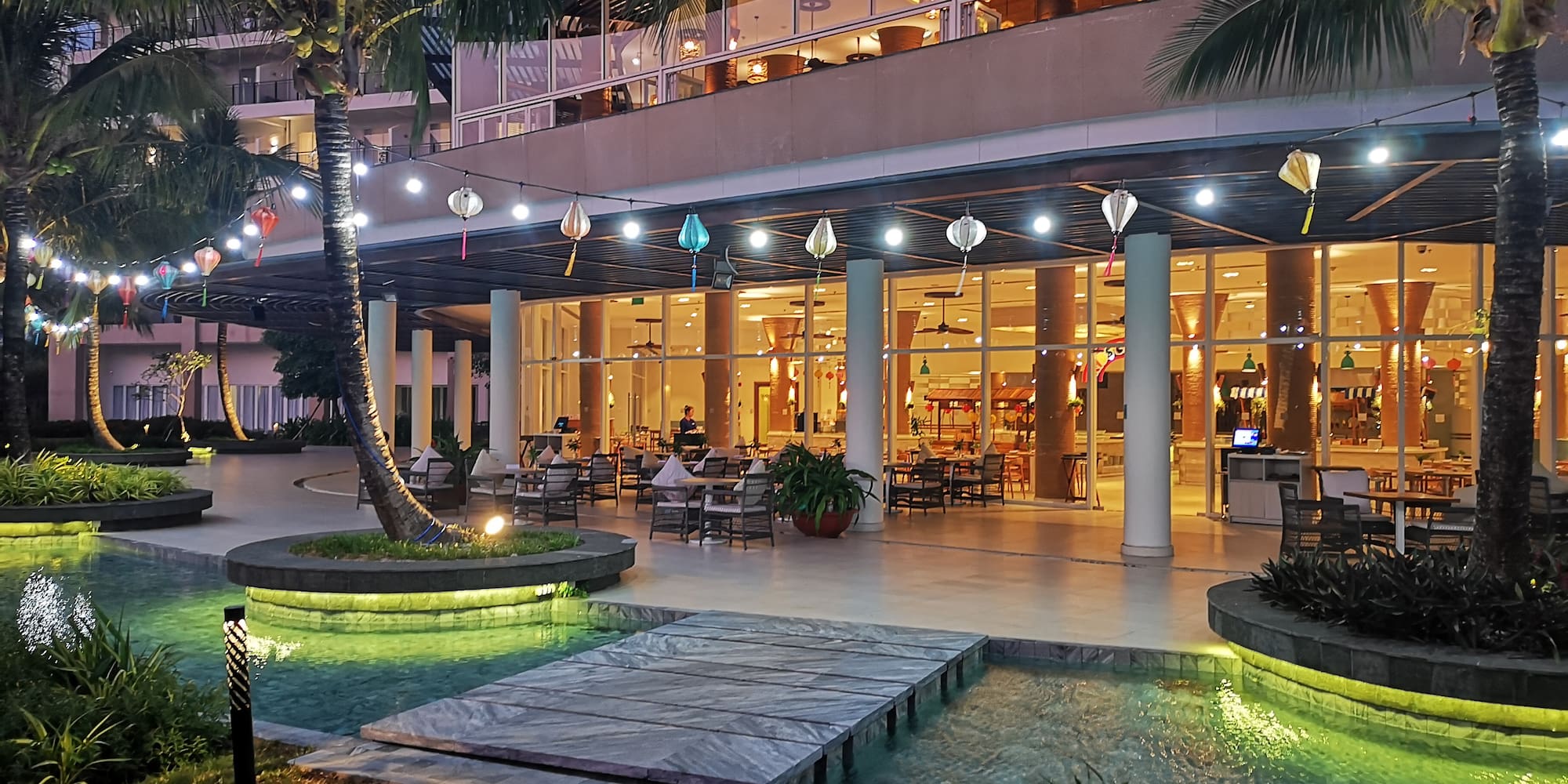 a building with a pool and palm trees