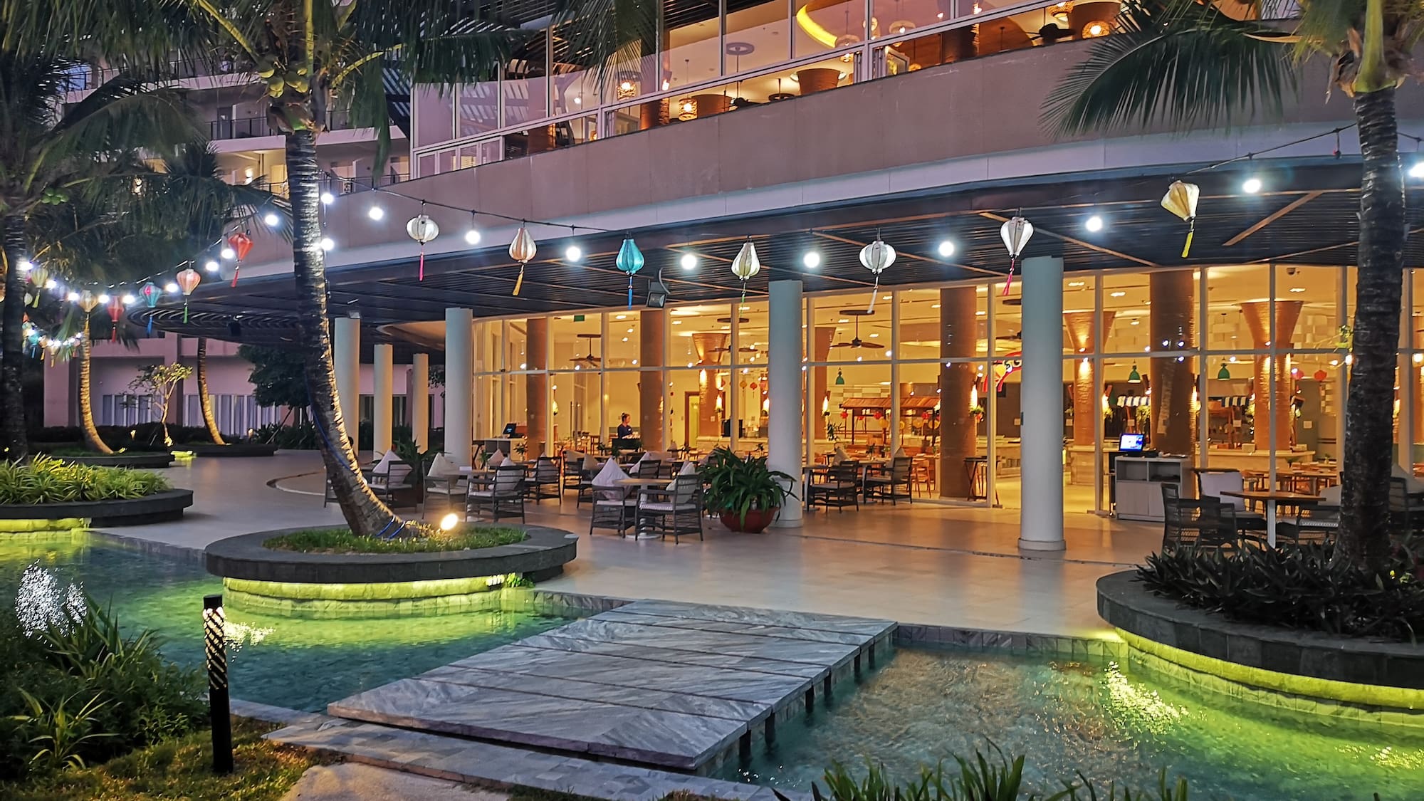 a building with a pool and palm trees