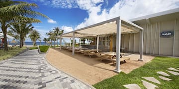 a building with a covered patio and a beach