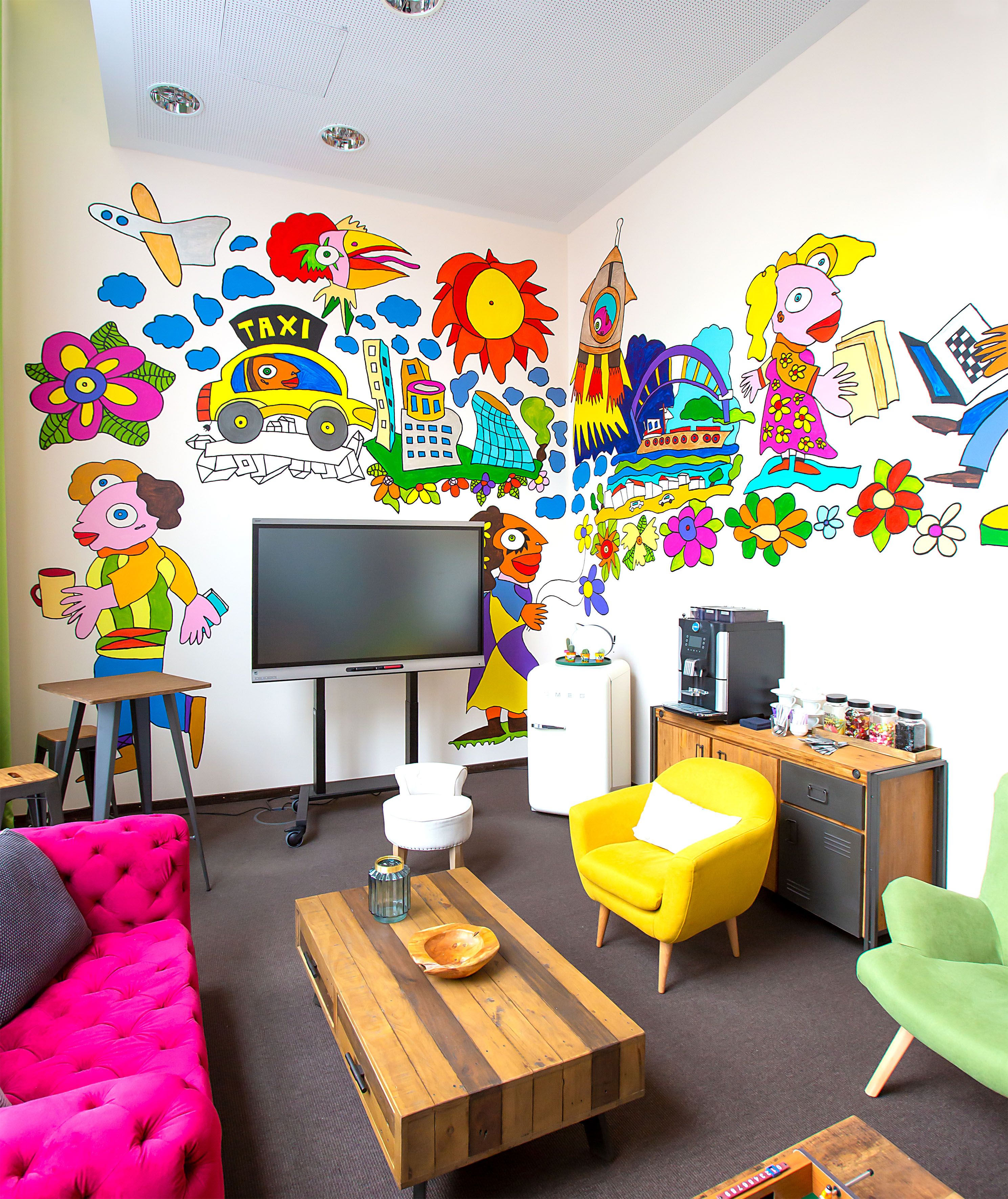 Colorful room with whimsical wall art, vibrant modern furniture, and coffee bar.