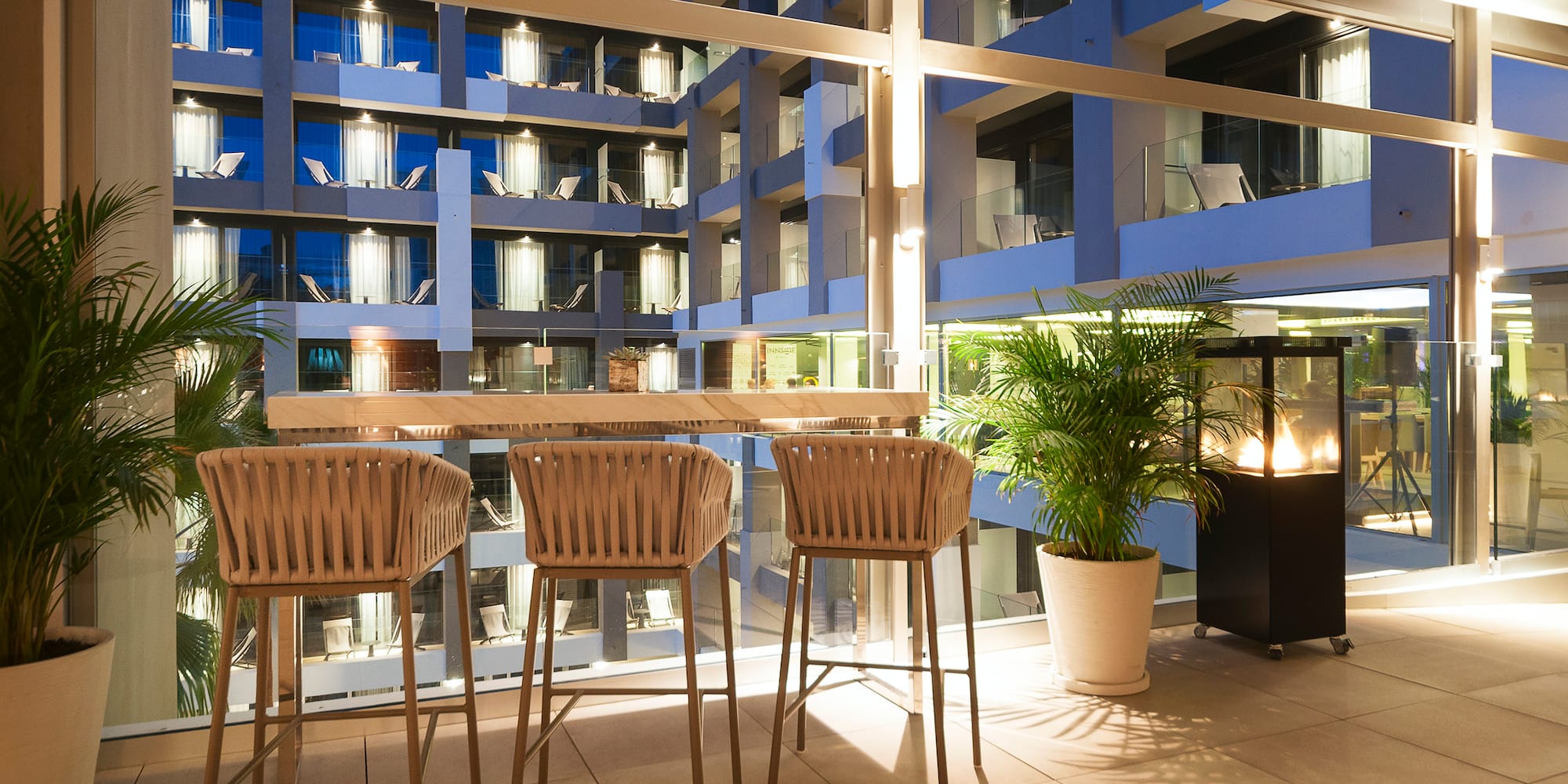 a table and chairs in a room with a glass wall and a building