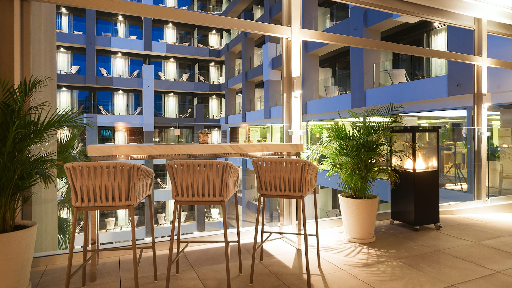 a table and chairs in a room with a glass wall and a building
