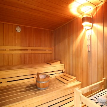 a wooden sauna with a bucket and a bench