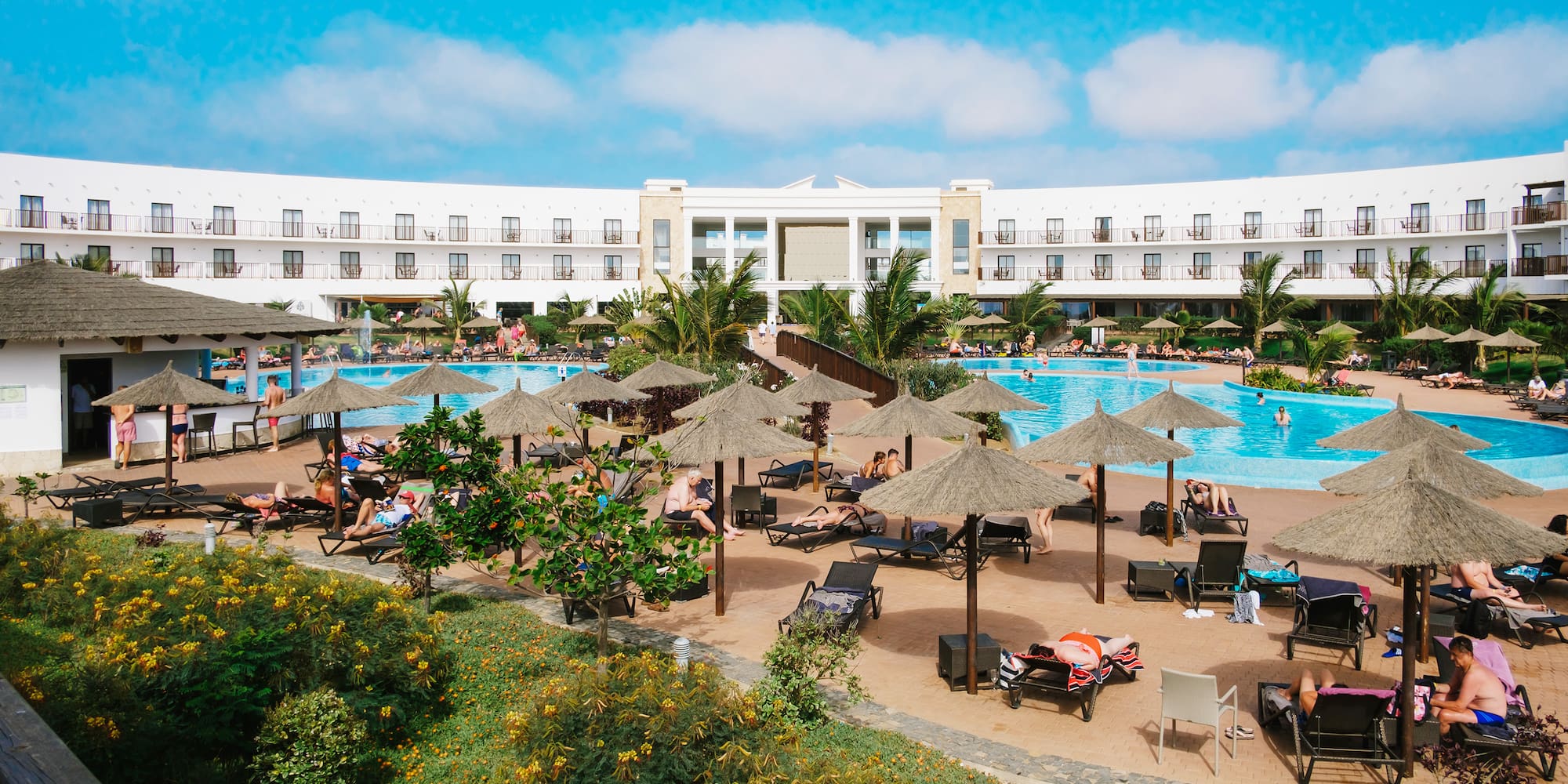 a pool with umbrellas and people around it