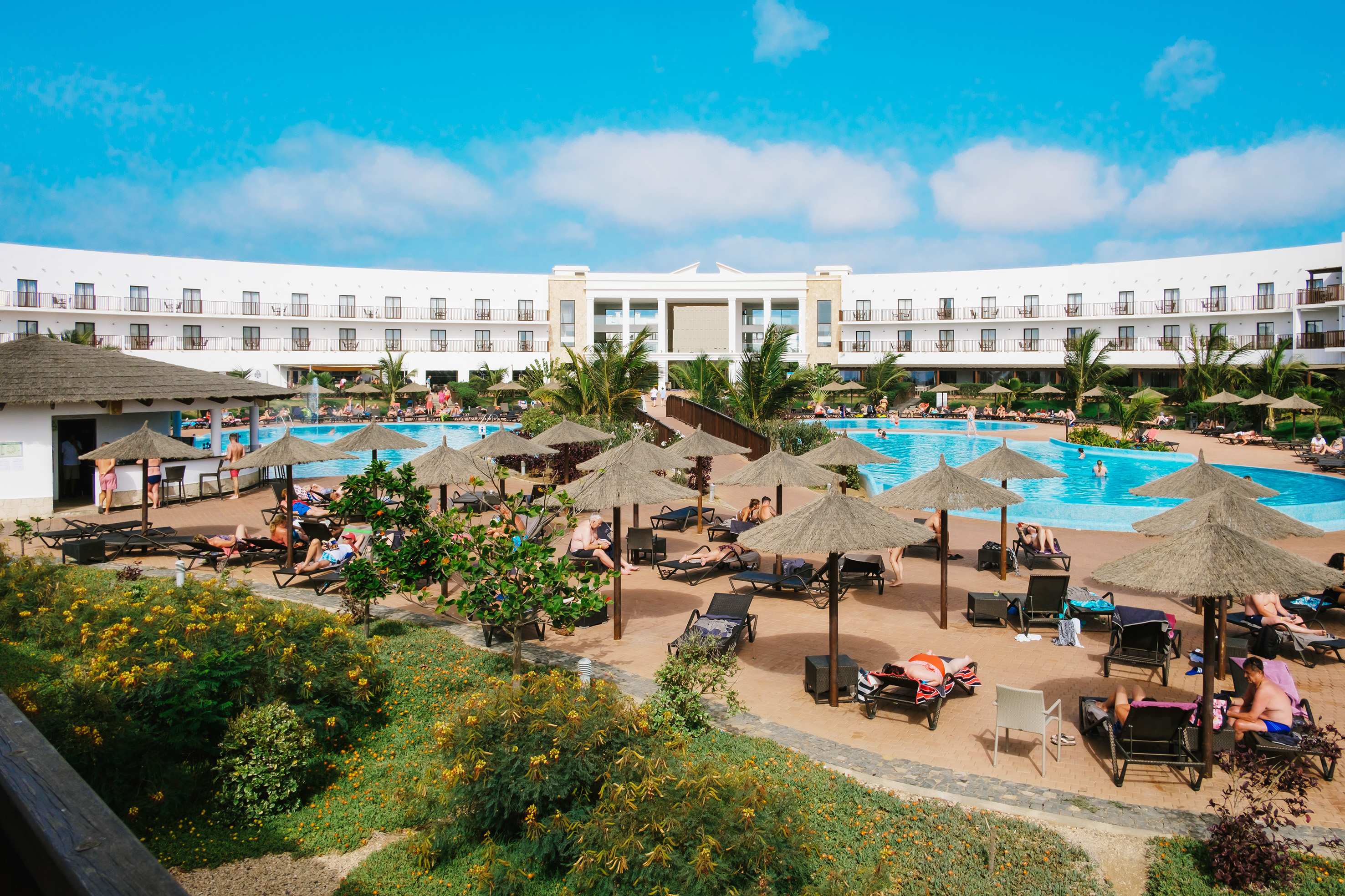 a pool with umbrellas and people around it