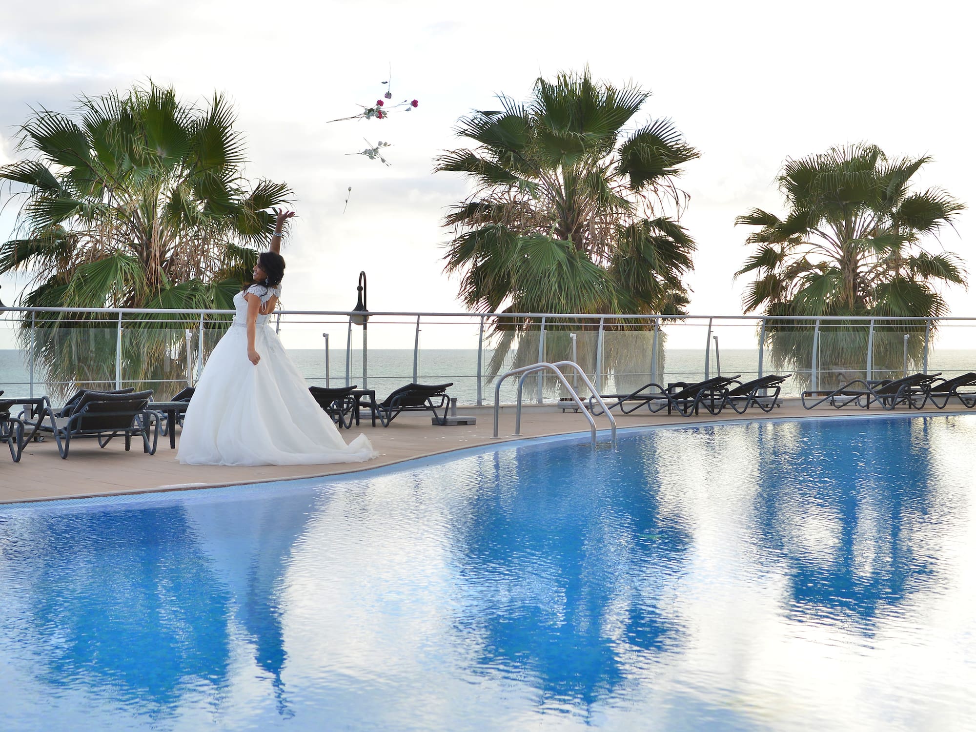 a woman in a wedding dress by a pool