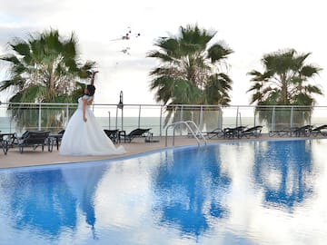 a woman in a wedding dress by a pool