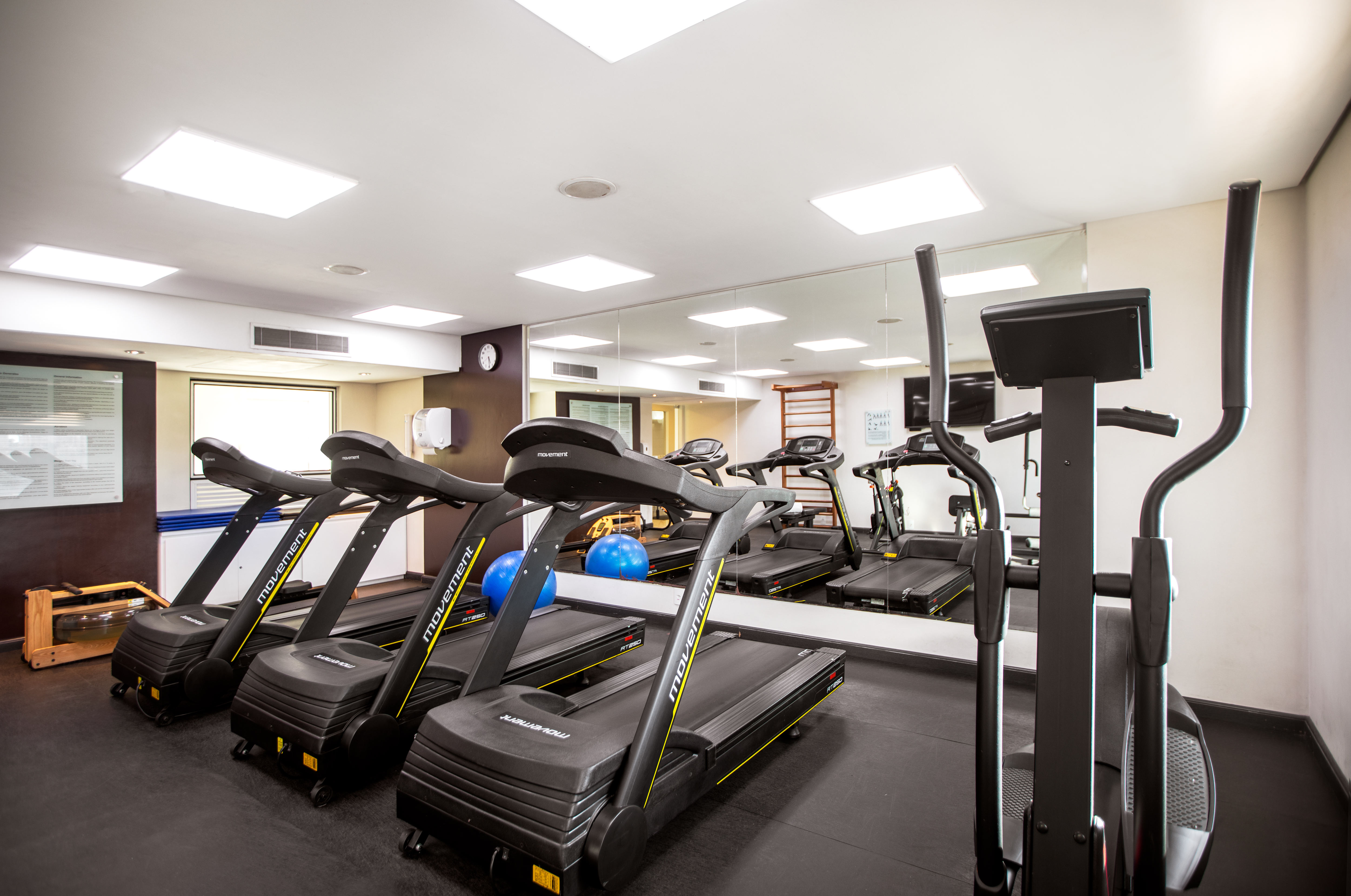 Hotel gym with several treadmills, elliptical machine, and rowing machine.