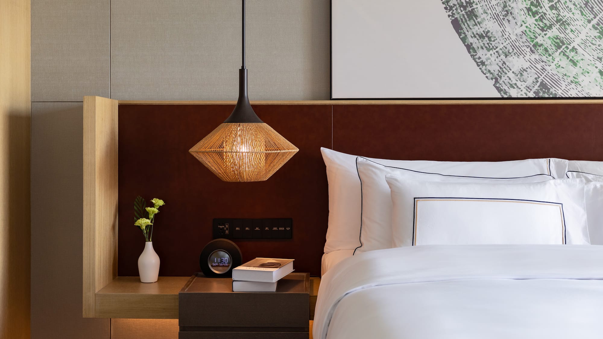 a bed with a lamp and a book on a table