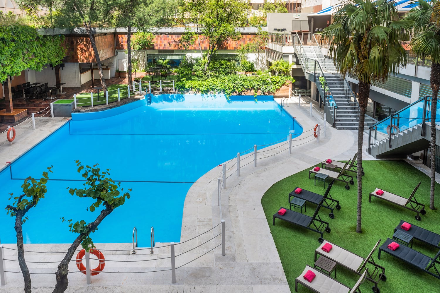 a swimming pool with lounge chairs and grass