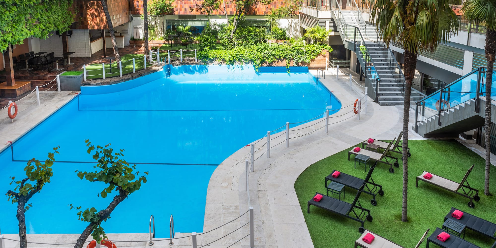 a swimming pool with lounge chairs and grass