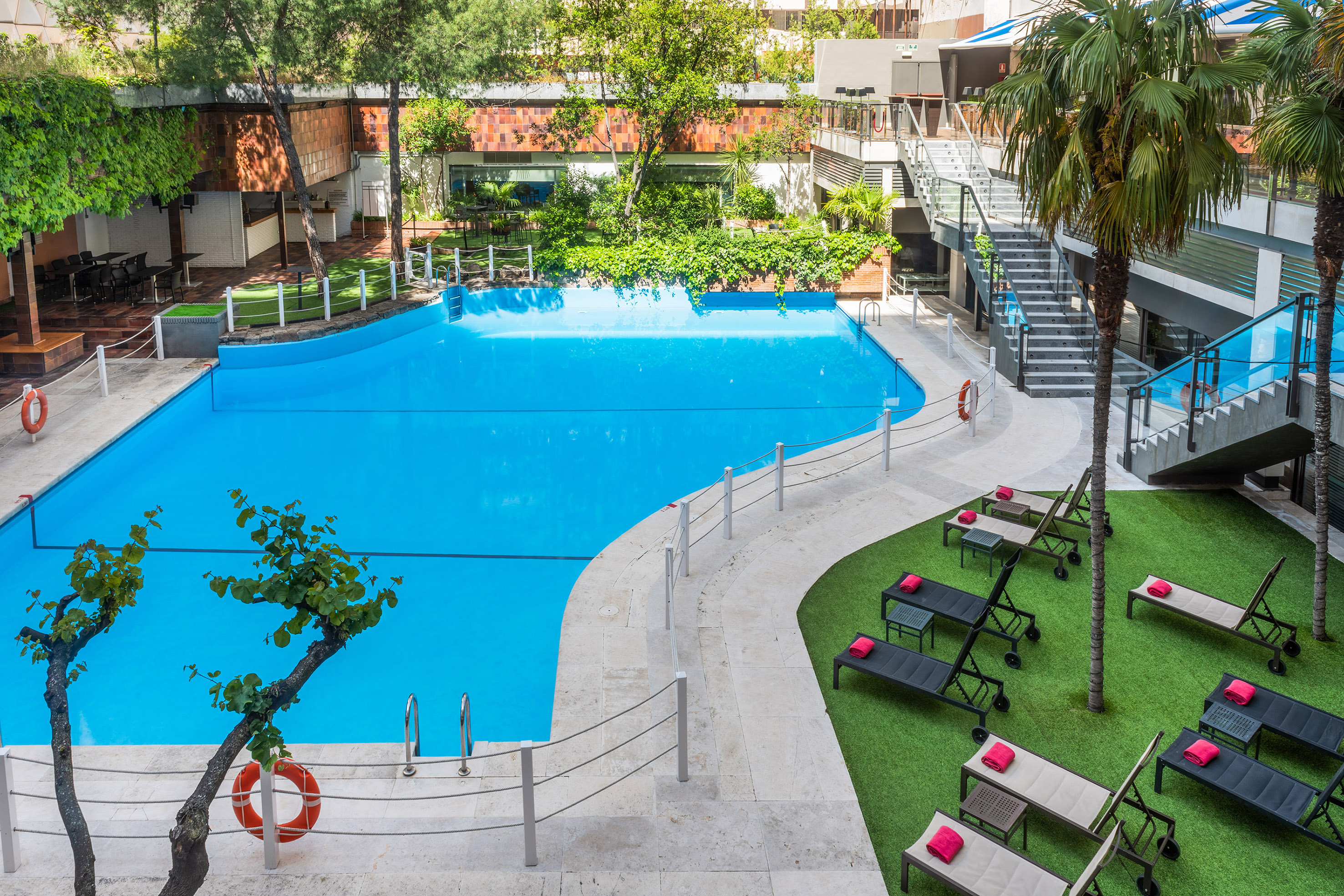 a swimming pool with lounge chairs and grass