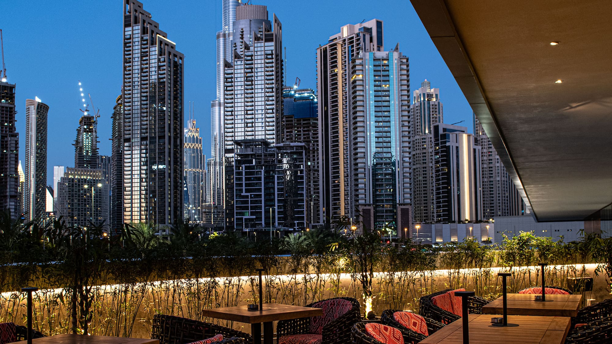 a rooftop restaurant with a city skyline in the background