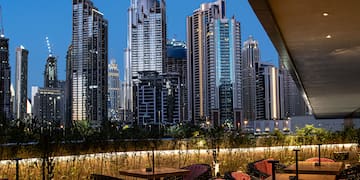 a rooftop restaurant with a city skyline in the background
