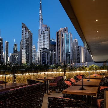 a rooftop restaurant with a city skyline in the background