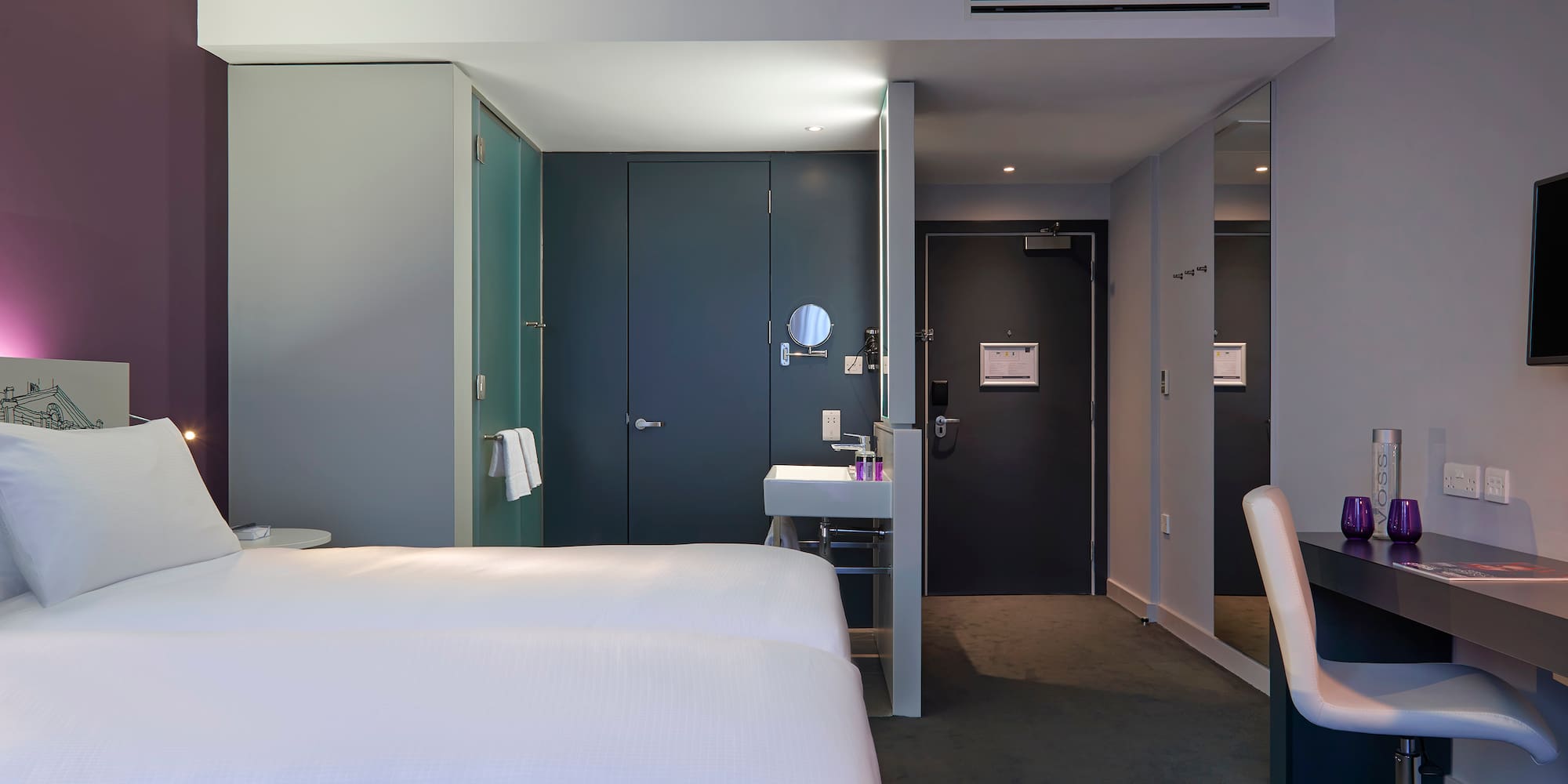 a room with two beds and a sink