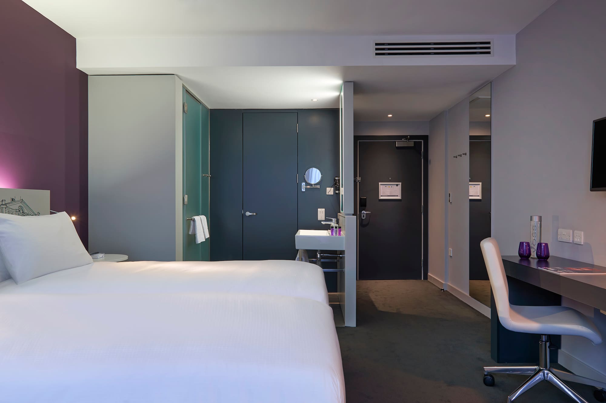 a room with two beds and a sink