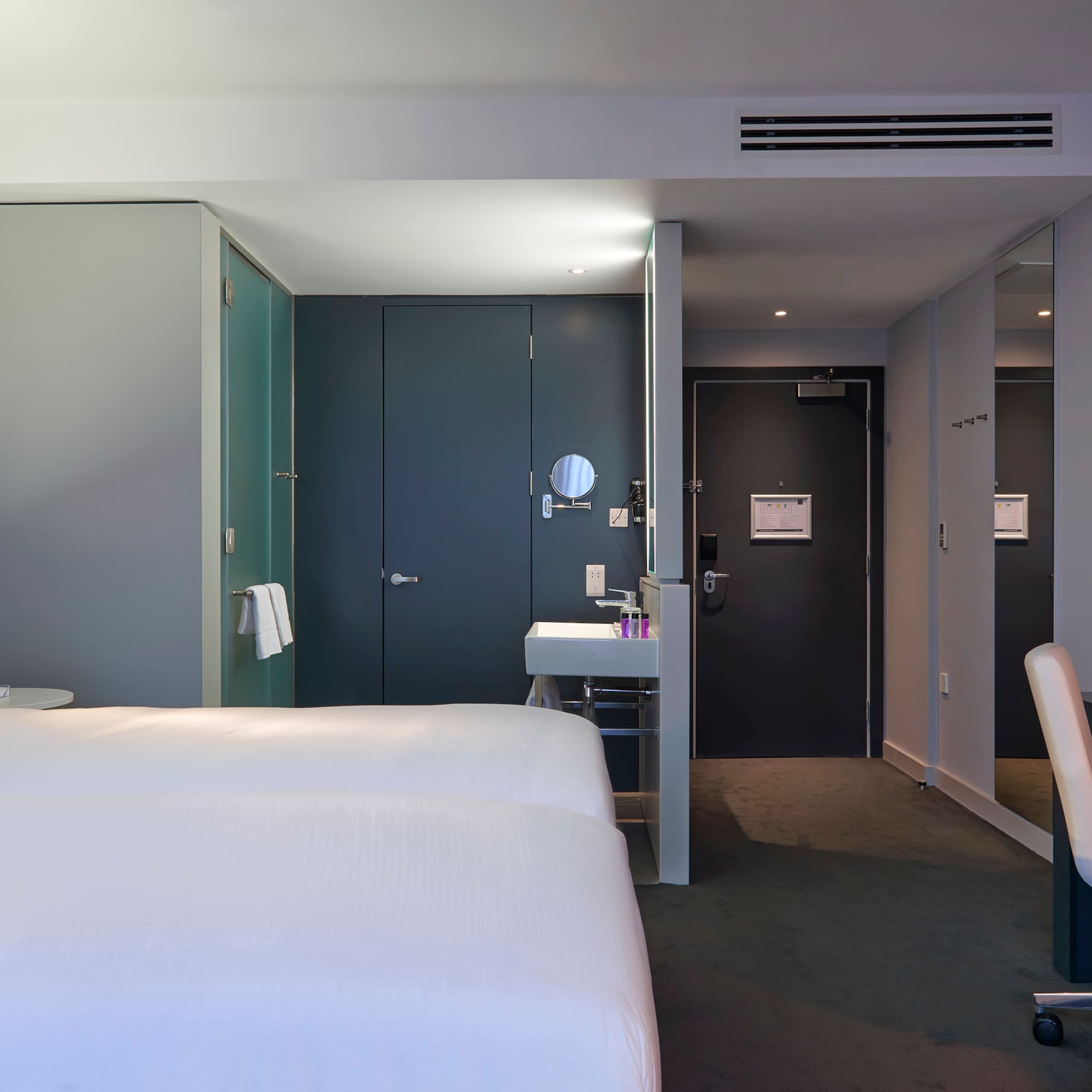 a room with two beds and a sink