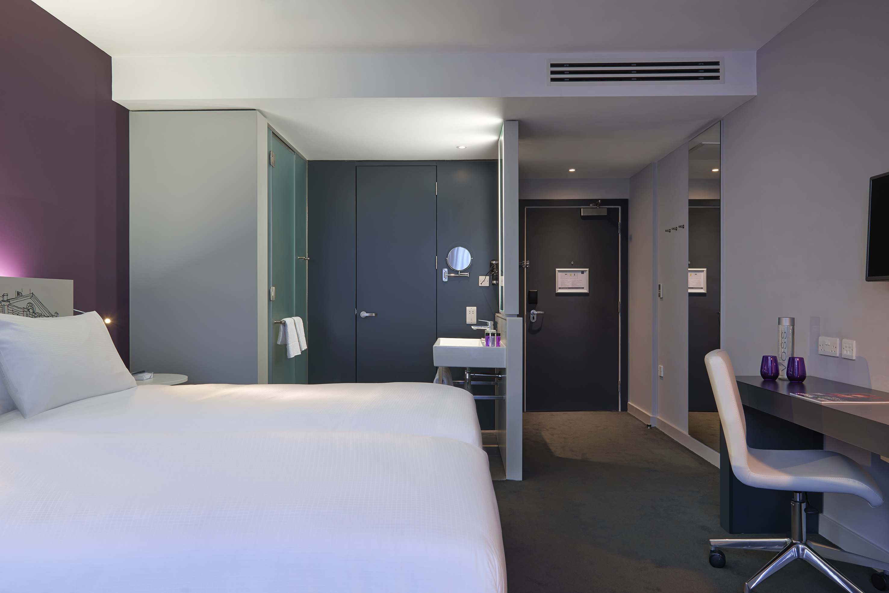 a room with two beds and a sink