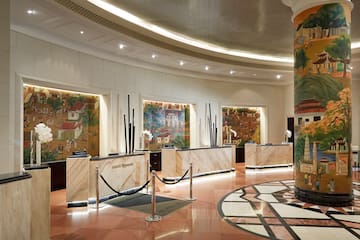 um lobby com balcão de mármore e piso de mármore
