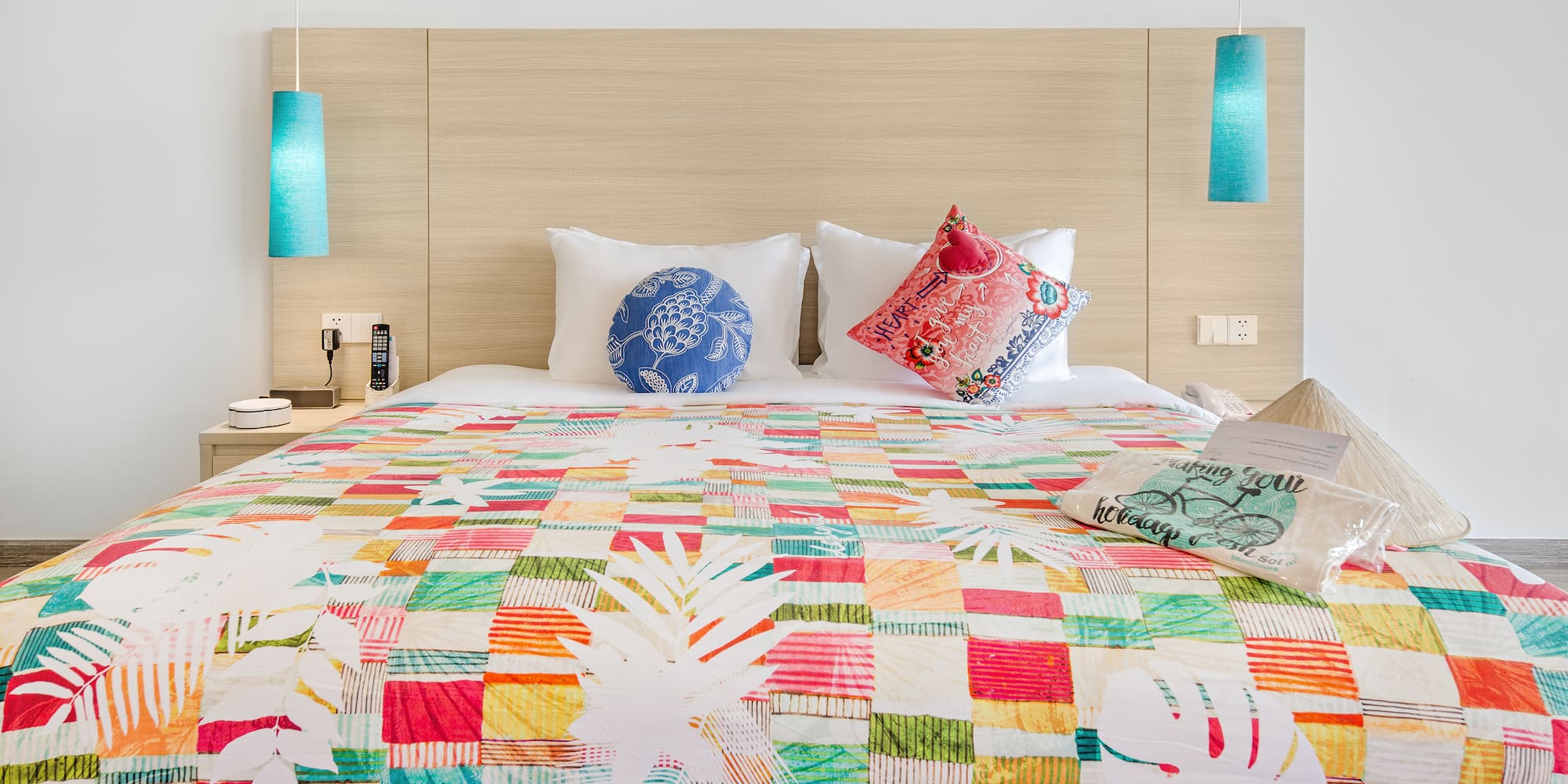 a bed with colorful bedding and pillows