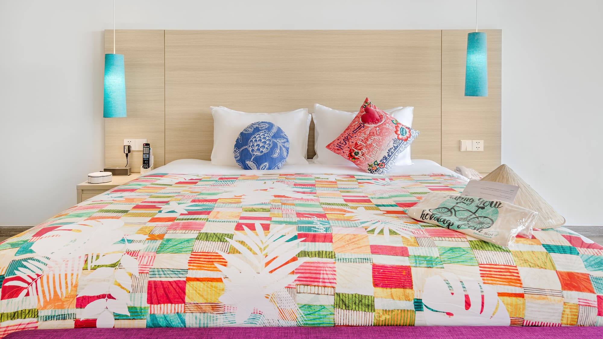 a bed with colorful bedding and pillows