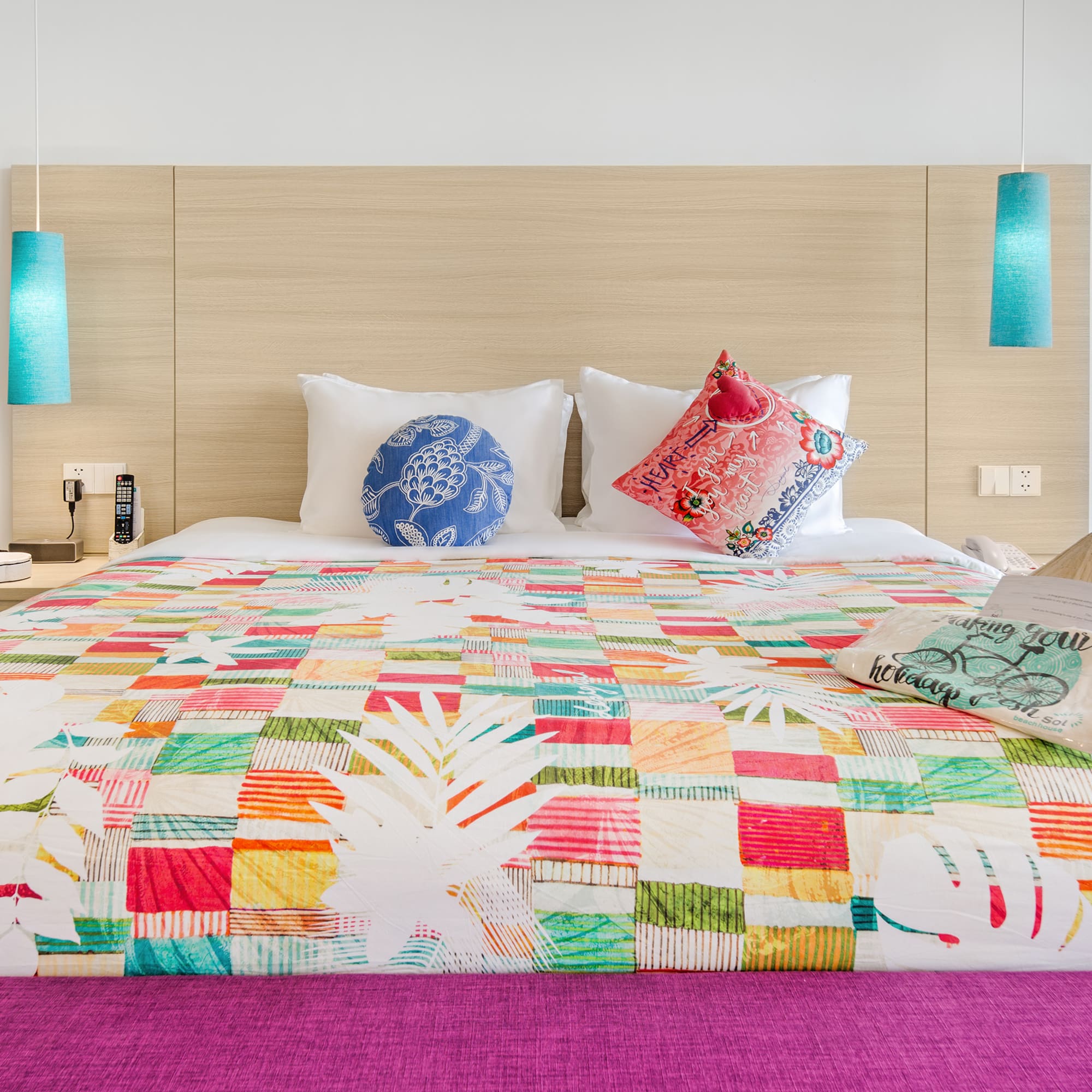 a bed with colorful bedding and pillows
