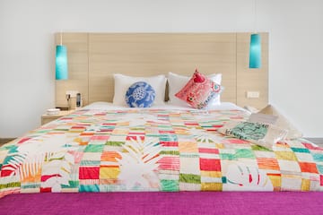 a bed with colorful bedding and pillows