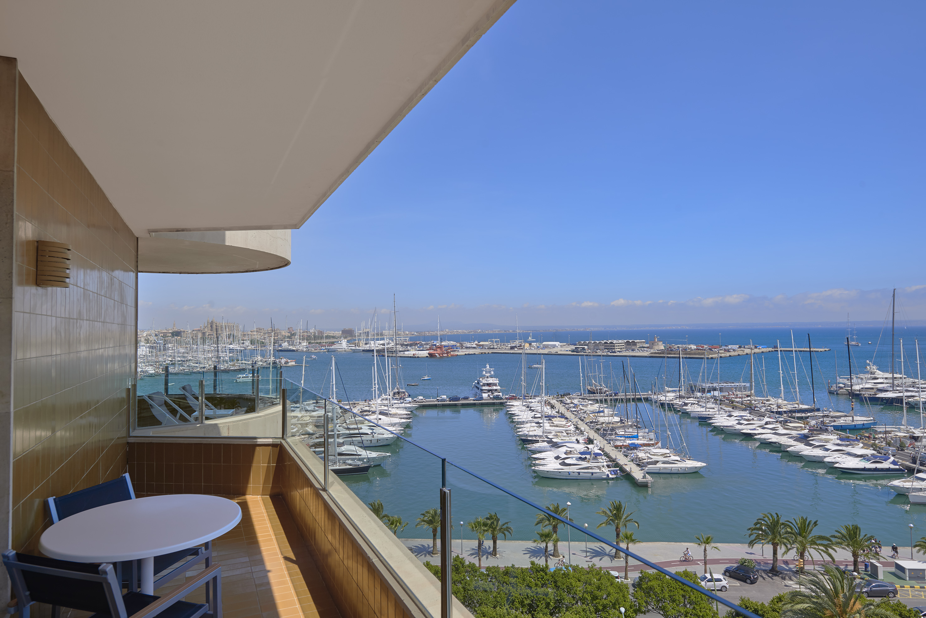 Balcony view of Palma de Mallorca marina, filled with yachts and blue sea.