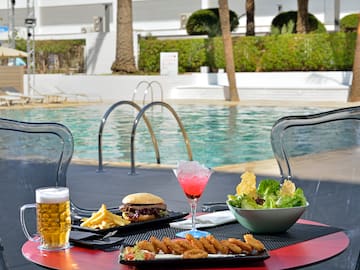 a table with food and drinks on it by a pool
