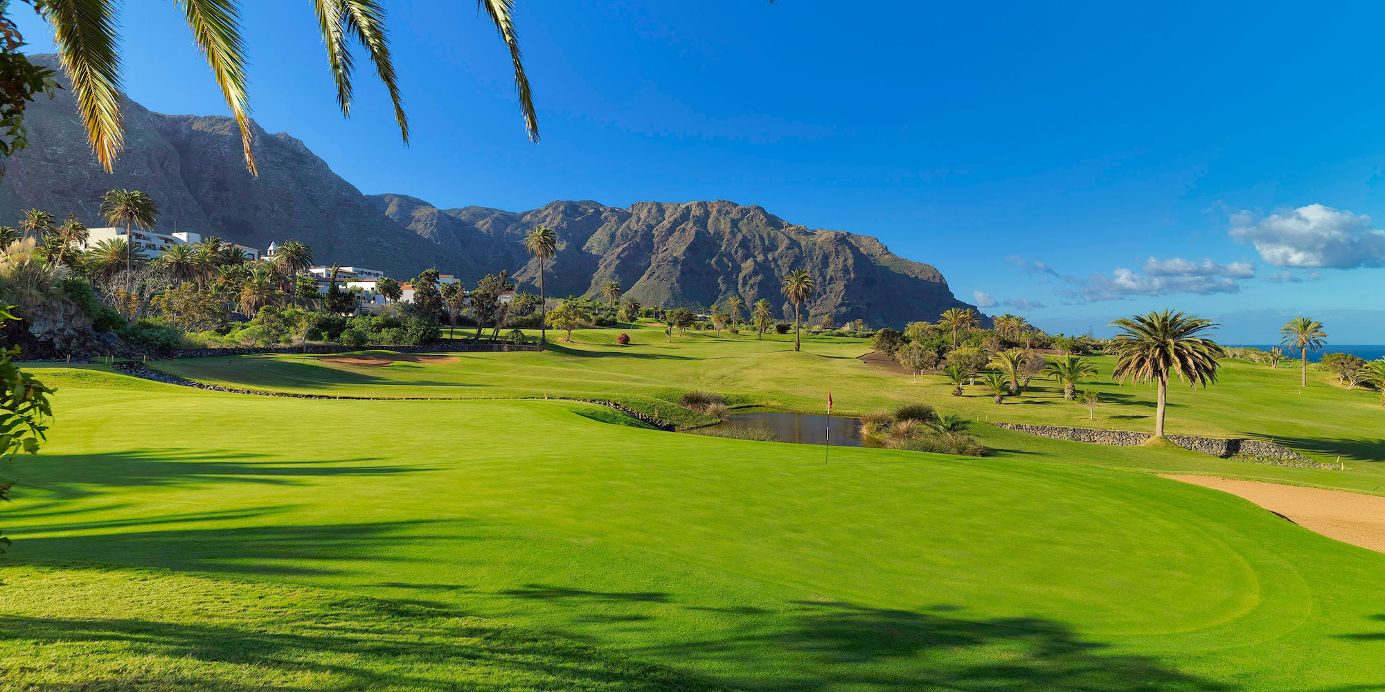 a golf course with a mountain in the background