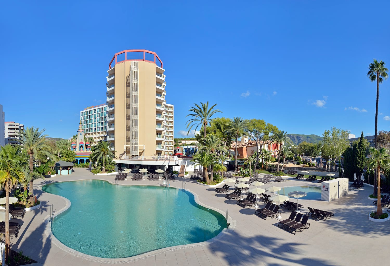 a pool with lounge chairs and a building in the background