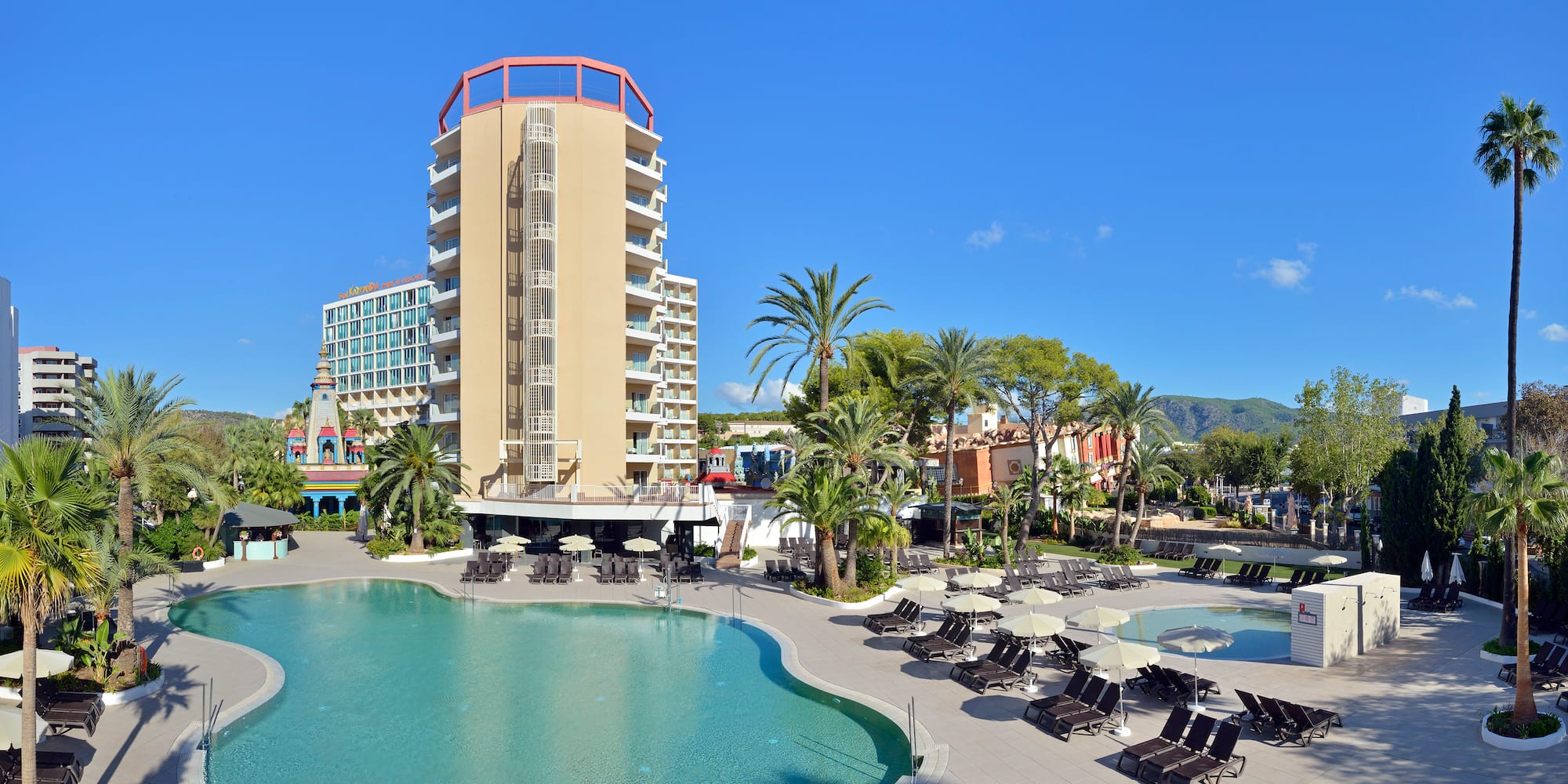 a pool with lounge chairs and a building in the background