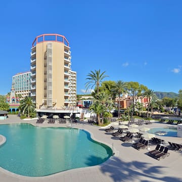 a pool with lounge chairs and a building in the background