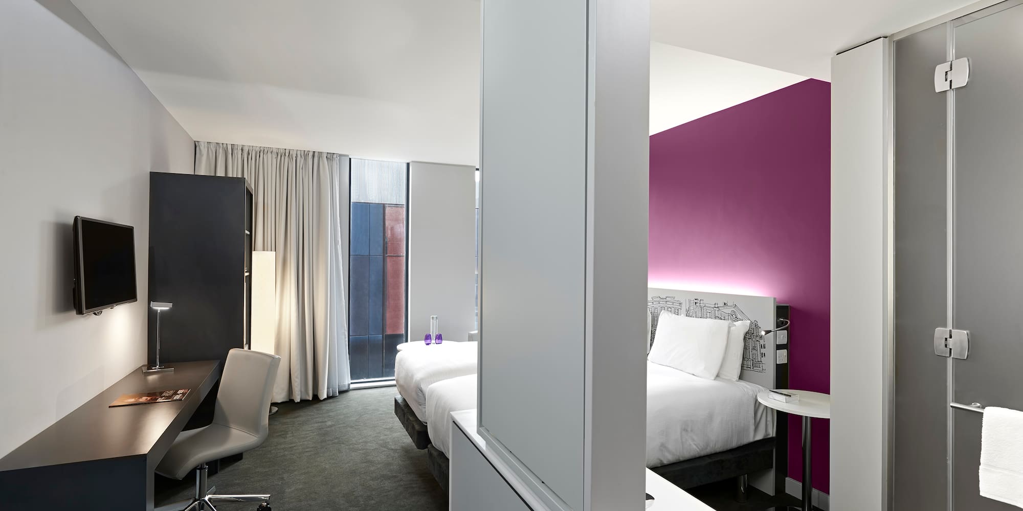 a room with two beds and a desk