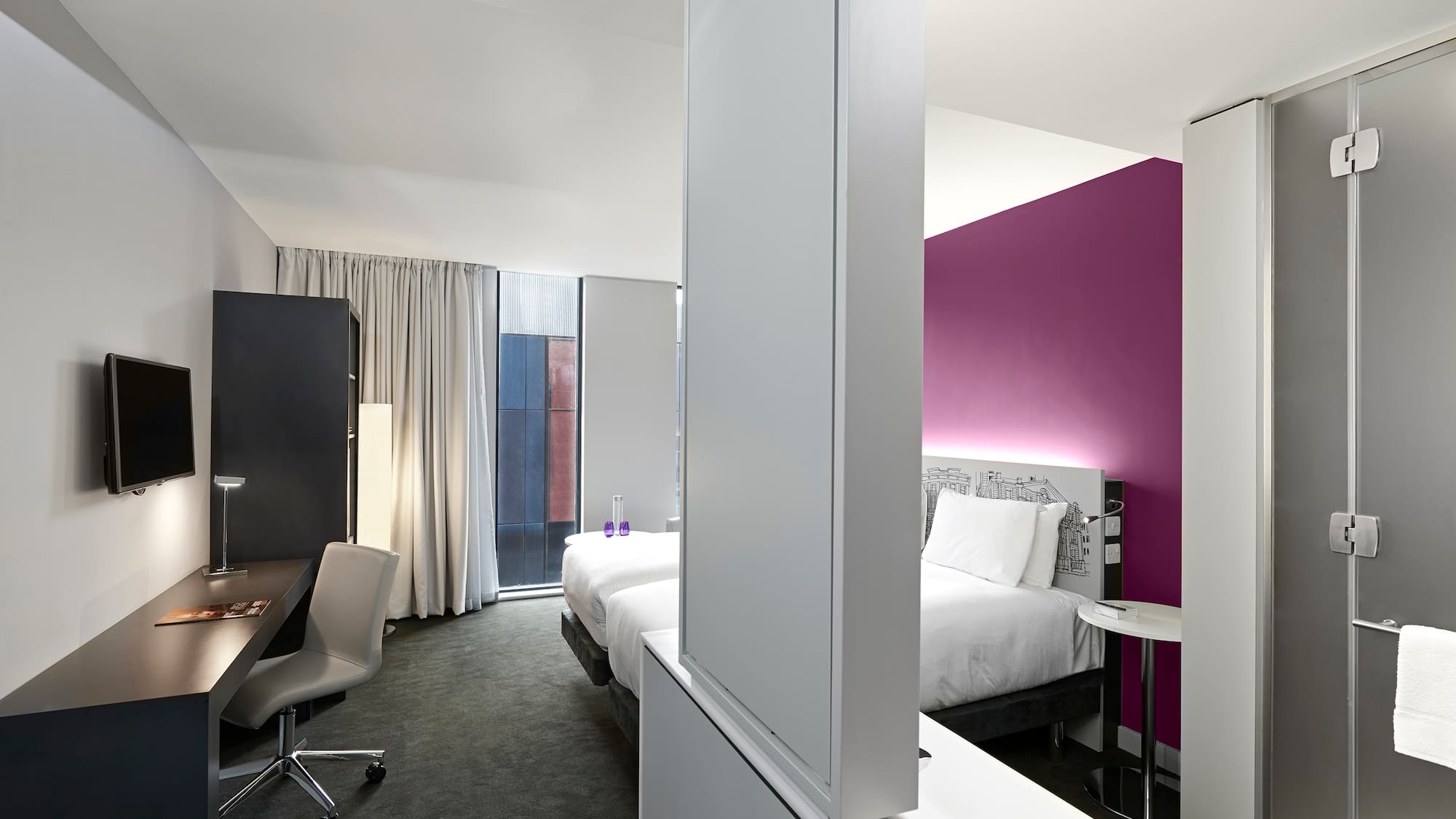 a room with two beds and a desk