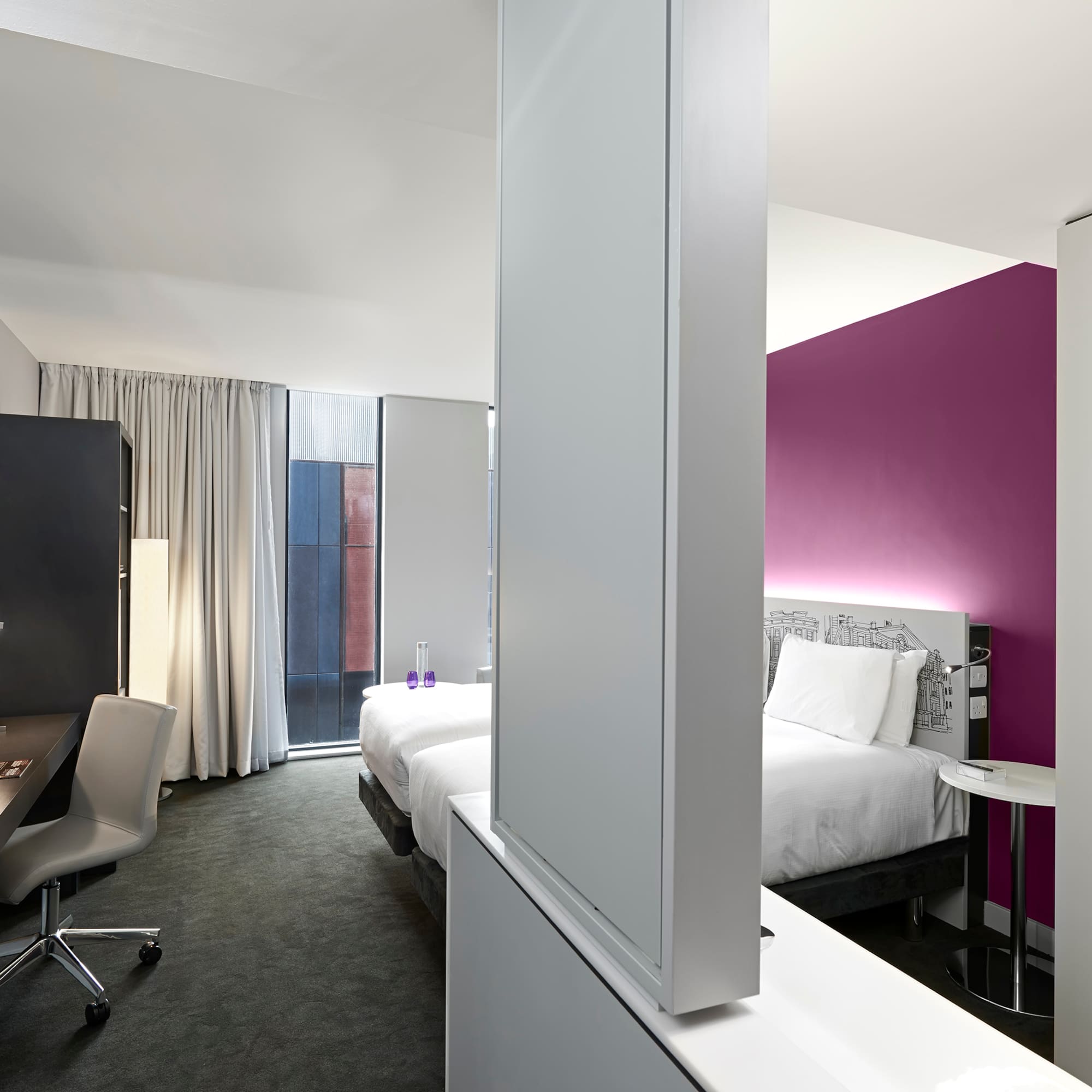 a room with two beds and a desk