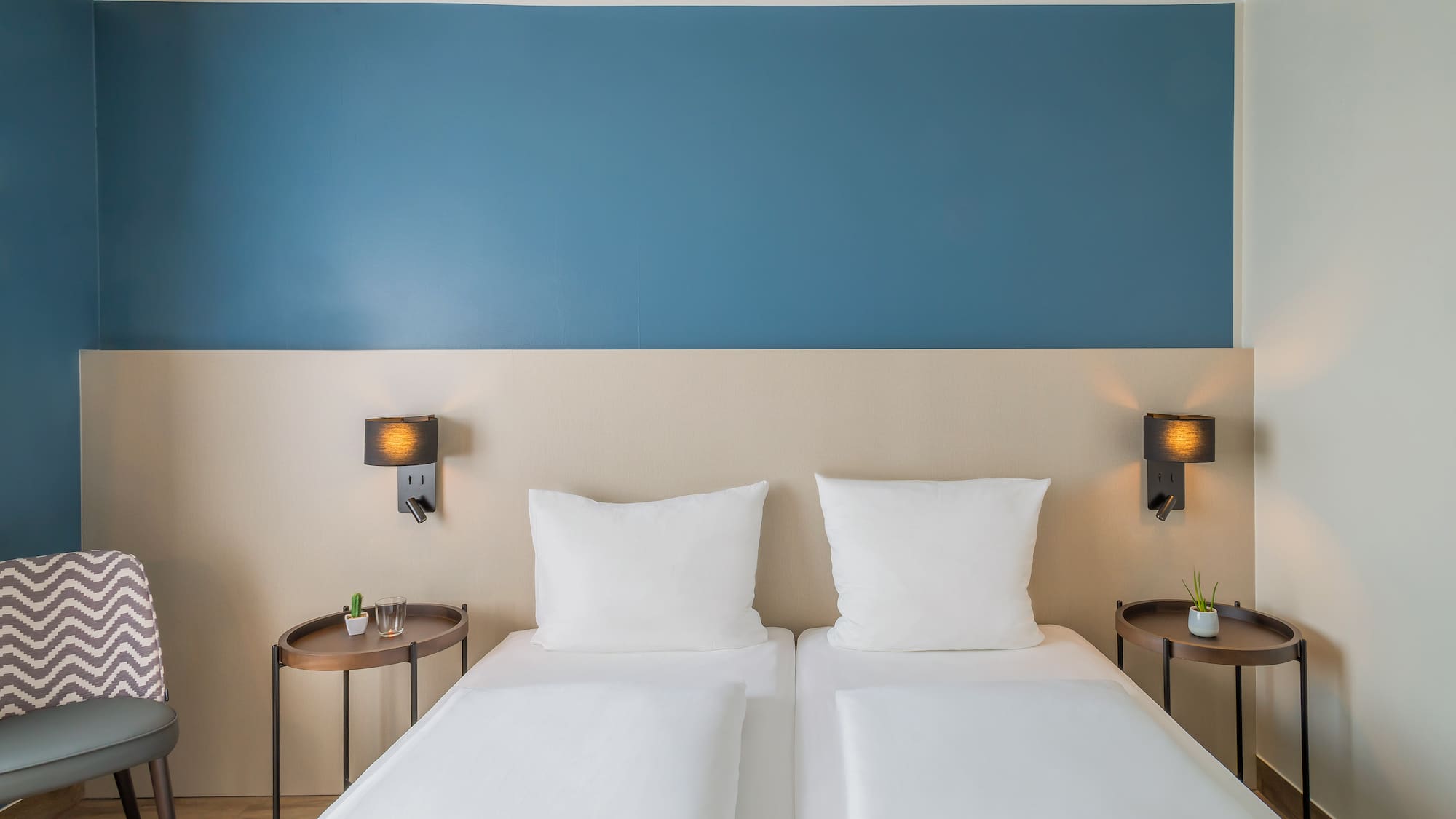 a bed with white pillows and a blue wall