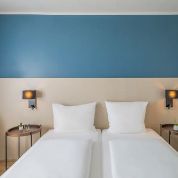 a bed with white pillows and a blue wall