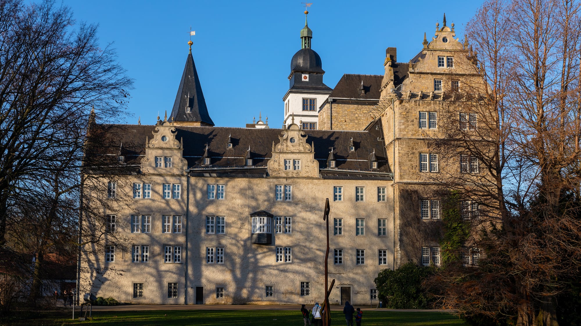 a large building with a lawn and trees