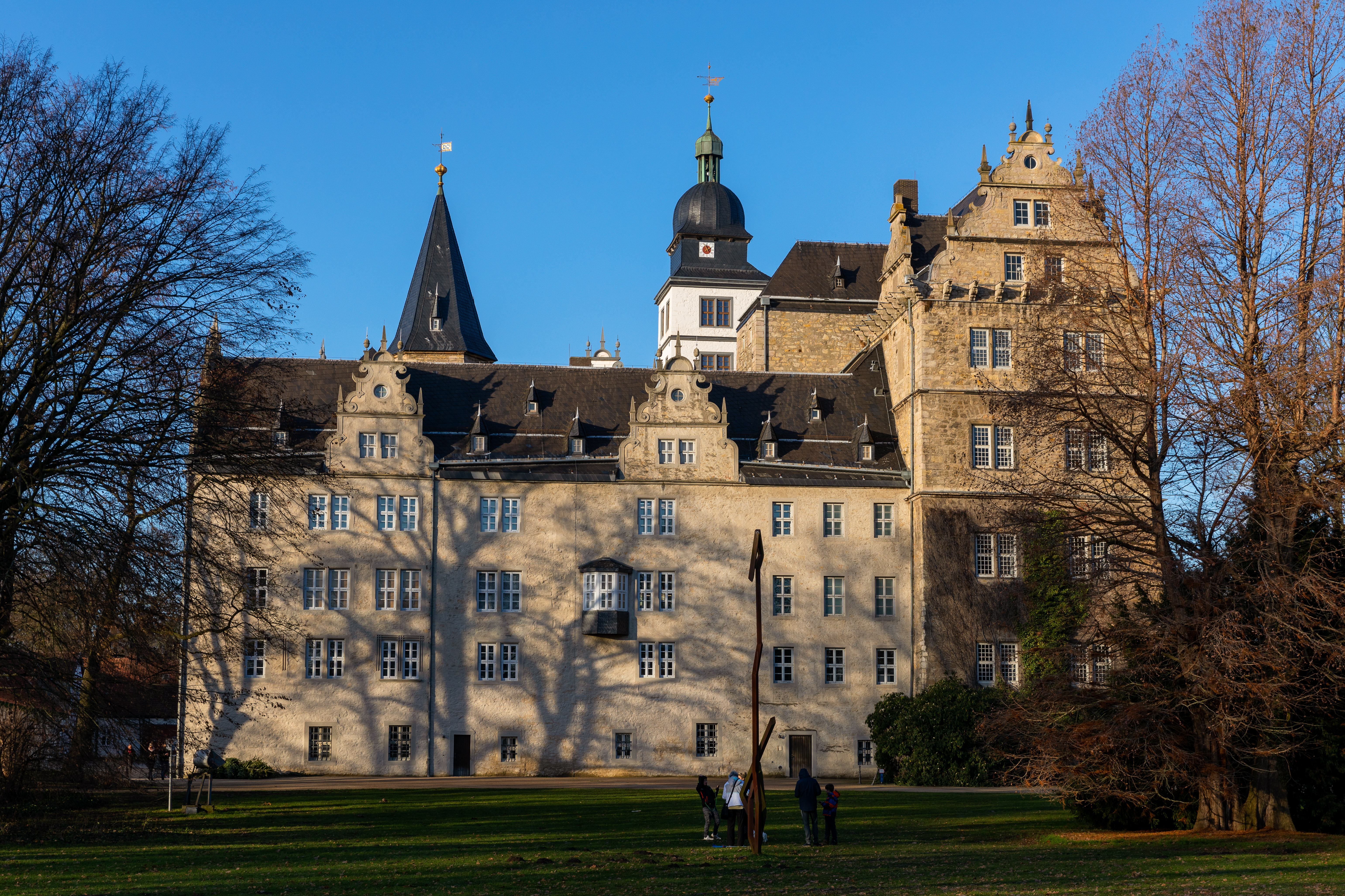 a large building with a lawn and trees