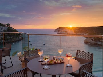 a table with food on it and a sunset over the water